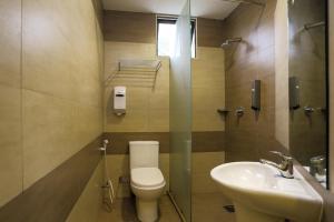 a bathroom with a toilet and a sink at Parkland Hotel in Brinchang