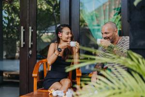 Un uomo e una donna seduti a un tavolo a bere caffè di D and B Bungalow's by DeWizZ Management a Nusa Lembongan Altre 43 foto