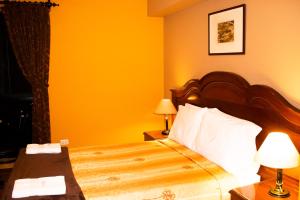 Habitación de hotel con cama con paredes amarillas en Solis Dies Hotel, en Lima