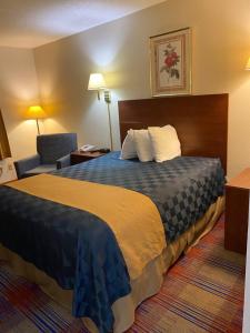 Habitación de hotel con cama y silla en Americas Best Value Inn Champaign, en Champaign