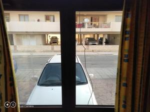 een uitzicht op een witte auto door een raam bij -= Studio Love =- in Xylophaghou