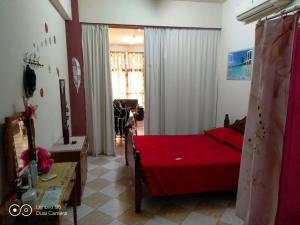 Un dormitorio con una cama roja en una habitación. en -= Studio Love =-, en Xylophaghou