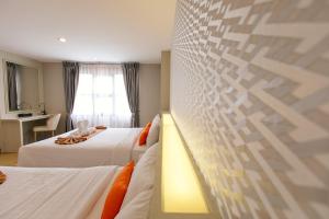 Ένα ή περισσότερα κρεβάτια σε δωμάτιο στο De Hug Hotel & Residence