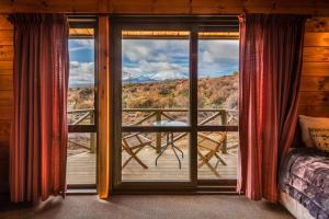 a bedroom with a view of the mountains from a window at Skotel Alpine Resort in Whakapapa Village