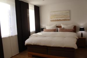 una camera da letto con un grande letto con cuscini bianchi e rosa di Luxuriöse Stadtwohnungen in Königstein a Königstein