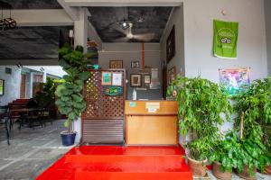 a restaurant with potted plants and a red floor at Joe Fisherman Inn in Pangkor