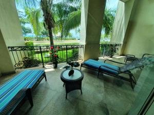 a balcony with two blue benches and a table at Villa Segovia @ Landmark by the Sea in Cozumel