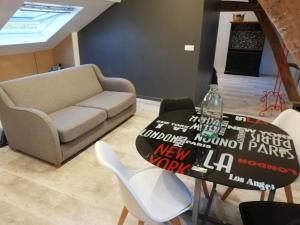 uma sala de estar com uma mesa e um sofá em Au cochon qui rit em Flines-lès-Mortagne