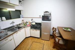 a kitchen with a sink and a stove and a table at Demachi 2 in Kyoto