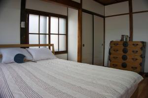 a bedroom with a large bed with a wooden headboard at Munetada House in Kyoto