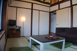 a living room with a table and a couch at Munetada House in Kyoto
