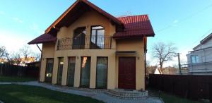 a small house with a balcony on top of it at Pensiunea Vila Mocanilor in Săcele