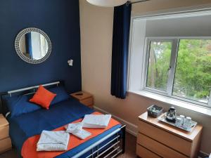 sypialnia z niebieskim łóżkiem i oknem w obiekcie Mount Stuart Hotel w Bournemouth