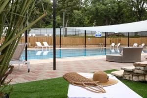 a swimming pool with a hat on a table next to at Eden Inn in Zikhron Ya'akov