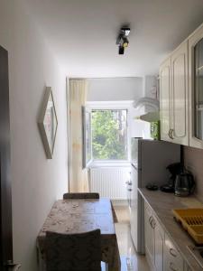 une cuisine avec une table et une fenêtre dans l'établissement Le Garçon de Cristina-Simple,Quiet,Spacious Studio, à Bucarest