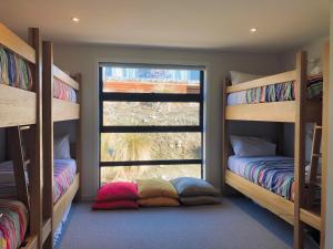 a room with two bunk beds and a window at Mackenzie Crib in Lake Tekapo