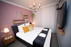 a bedroom with a large white bed with yellow pillows at Migdalor apartments Tiberias in Tiberias