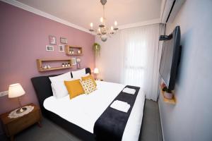 a bedroom with a large white bed and a tv at Migdalor apartments Tiberias in Tiberias