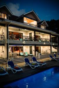 a villa with a swimming pool at night at CocoLux Luxury Apartments in La Digue