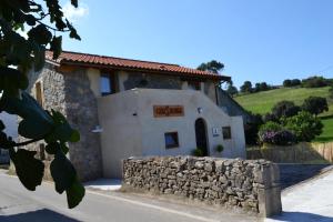 un edificio con una pared de piedra delante de él en CASA SOLORGA - apartamentos rurales, en San Miguel de Meruelo