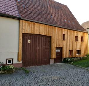 a large wooden barn with a large door at Häusle an der Hüle in Hohenstein