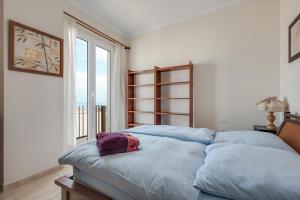 una camera da letto con un letto con lenzuola blu e una finestra di Casa Vacacional con Encanto a Puerto de la Cruz