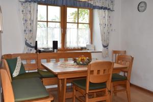 a dining room with a wooden table and chairs at Biohof Weissensteiner in Ullrichs