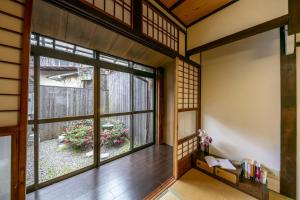 Koyasu - Traditional house near Silver Pavilion في كيوتو: غرفة آسيوية مع نافذة كبيرة وحديقة