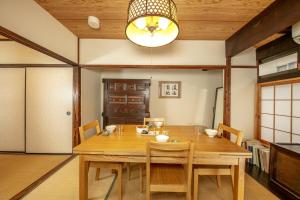 Koyasu - Traditional house near Silver Pavilion في كيوتو: غرفة طعام مع طاولة وكراسي خشبية