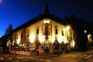 a lit up building on a street at night at Le Chatelet in Luxembourg