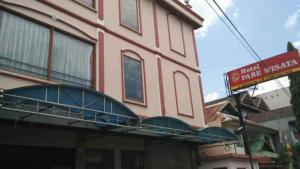 a pink building with a balcony on the side of it at Hotel Parewisata in Parepare