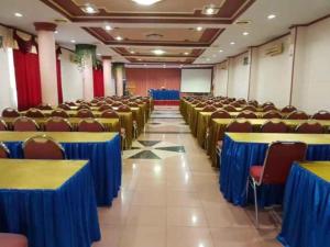 a room full of tables and chairs with blue table cloth at Hotel Parewisata in Parepare