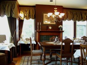 a dining room with a table and a fireplace at The Beacon Inn at Sidney in Sidney