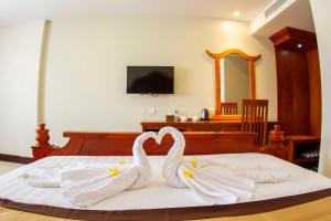two swans making a heart on a bed at Kampong Thom Palace Hotel in Kompong Thom