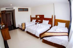 Postel nebo postele na pokoji v ubytování Kampong Thom Palace Hotel