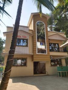ein Gebäude mit einer Palme davor in der Unterkunft Smita Villa in Alibag