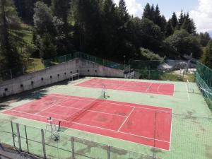 un court de tennis vide avec deux courts de tennis dans l'établissement Vetrate sul bosco, à Marilleva