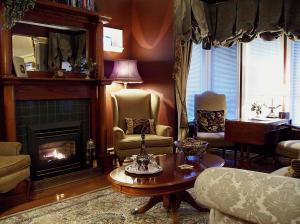 a living room with a fireplace and a table and chairs at The Beacon Inn at Sidney in Sidney