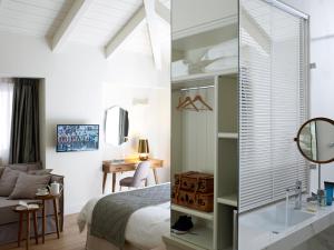 a bedroom with a bed and a desk and a mirror at Marpessa Hotel & Spa in Agrinion