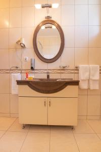 Hotel Wien في ديفا: حمام مع حوض ومرآة