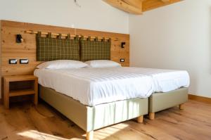 费德拉帕加内拉Bioagritur La Casa dei Trajeri的卧室里有一张铺着白色床单的大床