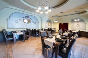 a restaurant with tables and chairs in a room at Hotel Wien in Deva