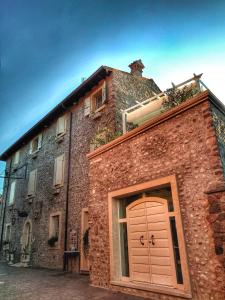 un bâtiment en brique avec une grande porte marron. dans l'établissement Maison Resola - Rooms & Breakfast, à Valeggio sul Mincio