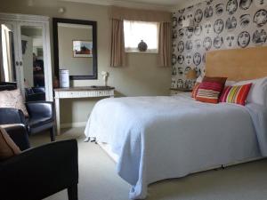 1 dormitorio con 1 cama blanca grande y espejo en Old Borough Arms en Rye