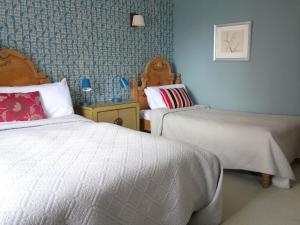 1 dormitorio con 2 camas y pared azul en Old Borough Arms en Rye