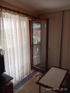 a living room with a mirror and a window at Konak Mali Raj in Vrnjačka Banja