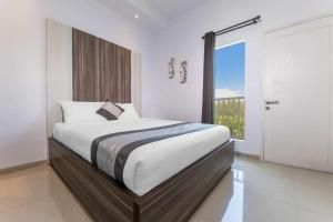 a bedroom with a large bed and a balcony at Umah Santi Residence in Ungasan