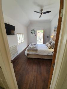 a bedroom with a bed and a ceiling fan at Old Thatch Bambers Green in Takeley
