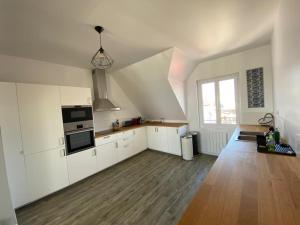 uma grande cozinha com armários brancos e uma janela em Appartement Quiberon em Quiberon