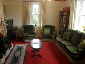 sala de estar con sofás, sillas y mesa en The Old Vicarage en Llanidloes